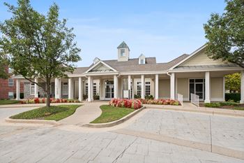 A building with a white cupola sits atop a brick foundation.